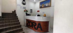 a lobby with a reception desk and stairs in a building at OYO Zora Luxury Rooms in Visakhapatnam