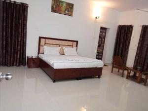 a bedroom with a bed and a table and a chair at OYO Zora Luxury Rooms in Visakhapatnam