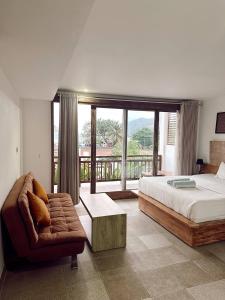 1 dormitorio con 1 cama, 1 silla y 1 ventana en HI5 Kuta en Kuta Lombok