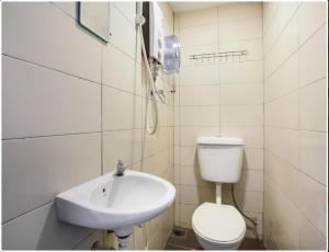 bagno bianco con lavandino e servizi igienici di NS INN Hotel a Malacca