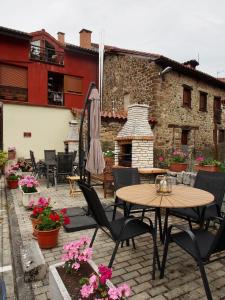 un patio con mesa, sillas y chimenea en Hostal Remoña en Espinama