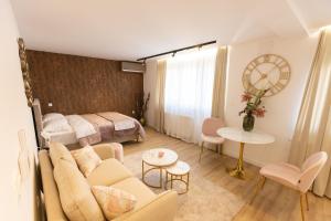 un soggiorno con un divano e un letto di Soho Boutique Apartman a Požega