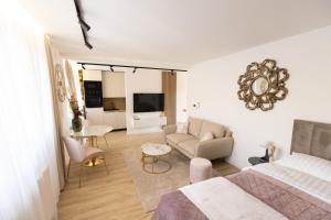 a bedroom with a bed and a living room at Soho Boutique Apartman in Požega