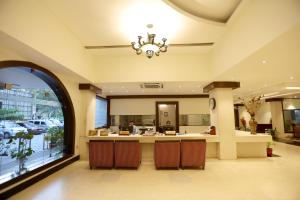 a lobby with a reception counter and a chandelier at Breeze Residency in Tiruchirappalli