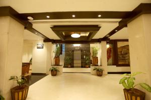 a hallway with potted plants in a building at Breeze Residency in Tiruchirappalli