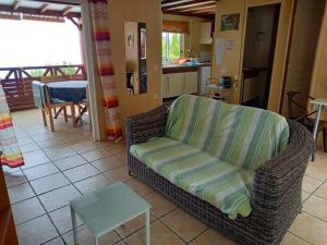 ein Wohnzimmer mit einem Sofa und einem Tisch in der Unterkunft Maison à Saint-Leu, vue panoramique sur l'océan à 2 minutes des plages in Saint-Leu