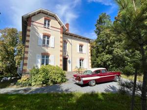 una vecchia macchina rossa parcheggiata di fronte a una casa di VILLA MEGUINELLE a Grand-Fougeray