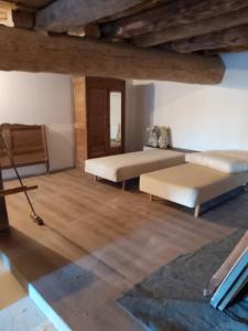 sala de estar con 2 camas y suelo de madera en Maison de 2 chambres a Lanarce a 800 m de la plage avec sauna et jardin clos, en Lanarce