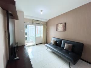 sala de estar con sofá negro y TV en Galeri Ciumbuleuit Apartment 1 2BR 1BA - code 9A en Bandung