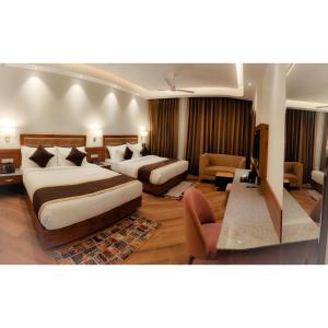 a hotel room with two beds and a living room at Hotel The Grand Dewan in Katra