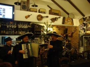 three men in hats playing instruments in a bar at Pensiunea TOTAL din Ceahlău in Ceahlău