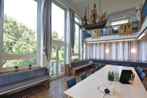 キールにあるユーゲントヘルベルゲ キールのテーブルと椅子、大きな窓が備わる客室です。