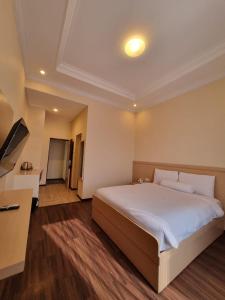 1 dormitorio con 1 cama grande y TV en core inn juwita hotel en Kepanjen