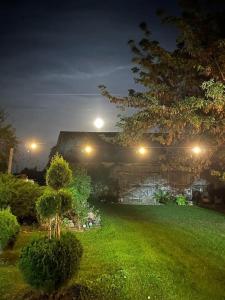 einen Garten in der Nacht mit Licht an einem Gebäude in der Unterkunft Kolonia u Jasia Rajgród in Rajgród