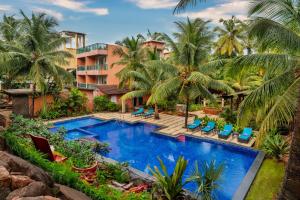 - une vue aérienne sur un complexe avec une piscine et des palmiers dans l'établissement Mandrem Beach Resort, a member of Radisson Individuals Retreat, à Mandrem