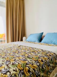 a bed with a colorful blanket on top of it at Villa TE URA Beach in Paea