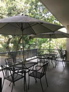 a group of tables and chairs with an umbrella on a balcony at ANNIE KUCA in Jakarta