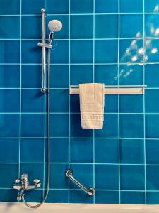 La salle de bains est pourvue de carrelage bleu, d'une douche et d'une serviette. dans l'établissement Al Ponte Lungo - Giudecca, à Venise