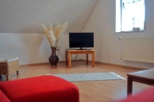 a living room with a tv sitting on a table at Ferienwohnung blaues Haus in Bischofsheim an der Rhön