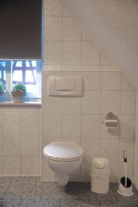 a white bathroom with a toilet and a window at Ferienwohnung blaues Haus in Bischofsheim an der Rhön