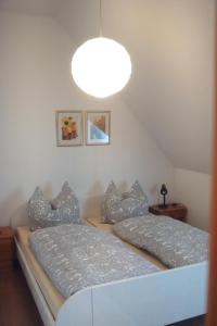two beds in a room with a large light fixture at Ferienwohnung blaues Haus in Bischofsheim an der Rhön