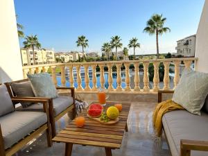 ein Tablett mit Obst auf einem Tisch auf einem Balkon in der Unterkunft Paradise Palms, 2bed Apt W Pool in Mandria