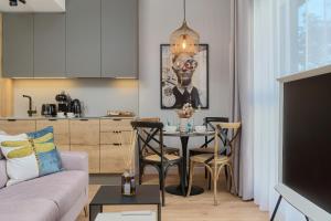 a living room with a table and a kitchen at Lux Apartment Plac Wolności 6 in Poznań Old Town by Renters Prestige in Poznań
