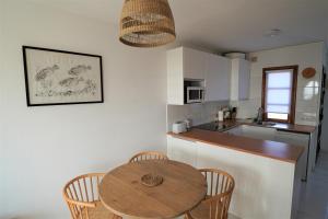 a kitchen with a wooden table and chairs and a counter at El Caleton Sea View Apartment in El Cotillo
