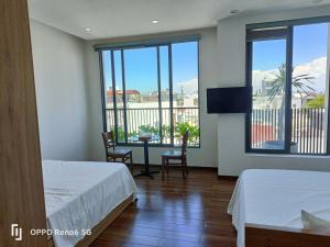 a bedroom with two beds and a view of a balcony at Tree Homestay in Da Nang