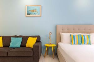 a bed and a couch in a room at Ramada Spacious Studio Apartment with Pool Views in Port Douglas +5 photos
