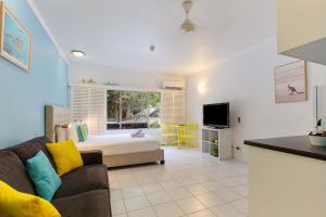 a living room with a couch and a kitchen at Ramada Spacious Studio Apartment with Pool Views in Port Douglas