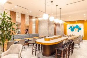 a restaurant with tables and chairs in a room at Travelodge Honmachi Osaka in Osaka