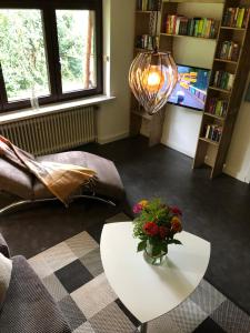 una sala de estar con una mesa con un jarrón de flores. en Unter Den Eichen, en Bötersen