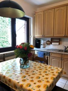 eine Küche mit einem Tisch und einer Blumenvase darauf in der Unterkunft Unter Den Eichen in Bötersen