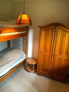 ein Schlafzimmer mit einem Etagenbett und einem Holzschrank in der Unterkunft Unter Den Eichen in Bötersen + 5 Fotos