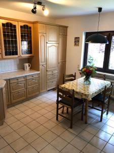 a kitchen with a table and chairs in a room at Unter Den Eichen in Bötersen +5 photos