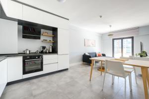 a kitchen and dining room with white cabinets and a table at Luminous Flat 7 min to Arcadium Mall in Ankara in Ankara