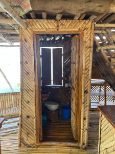 a bathroom with a toilet in a wooden house at Bamboo Nest Beachfront in Puerto Princesa City