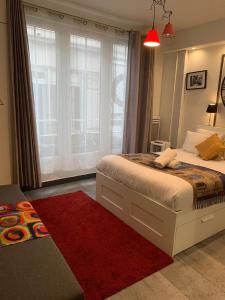 um quarto com uma cama grande e um tapete vermelho em 21 Atelier Chaplin Montorgueil em Paris