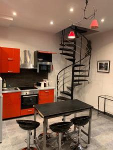 eine Küche mit einem Tisch und einer Wendeltreppe in der Unterkunft 21 Atelier Chaplin Montorgueil in Paris