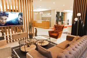 un soggiorno con divano, sedie e TV di City Night Suites & Hotels a Çekme