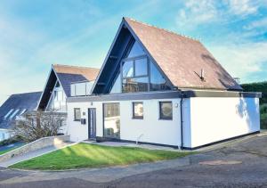 a large white house with a gambrel roof at Pebbles in Abersoch