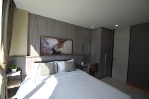 Un dormitorio con una cama blanca grande y una mesa en BTS 46 - Near BTS Phrakhanong, en Bangkok