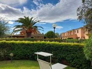 a white chair sitting in the grass in front of a hedge at Villa Vittoria in San Teodoro