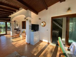 a living room with a tv and a room with a staircase at Villa Vittoria in San Teodoro