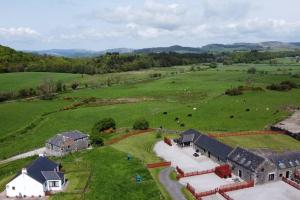 an aerial view of a farm with cows in a field at The Barn @ Clauchan holiday Cottages in Gatehouse of Fleet