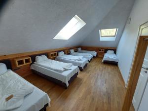 - une rangée de lits dans une chambre dotée de lucarnes dans l'établissement Vasaknų dvaras, à Žabičiūnai