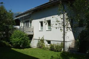 a white house with a balcony in a yard at Haus am Lahnbach in Schwaz