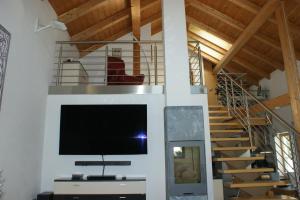 a living room with a tv and a staircase at Haus am Lahnbach in Schwaz