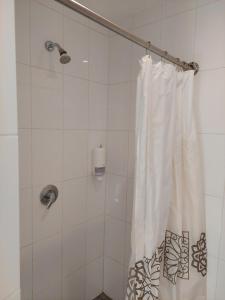W łazience znajduje się prysznic z białą zasłoną prysznicową. w obiekcie Vasaknų dvaras w mieście Žabičiūnai